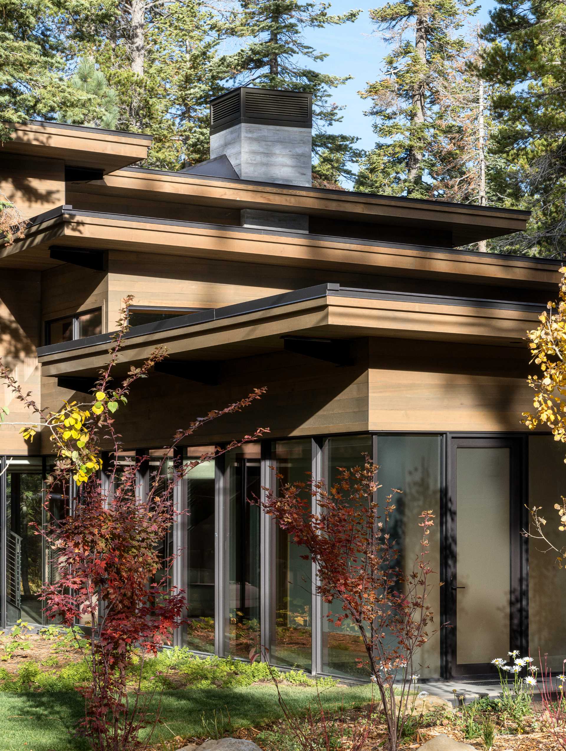 A modern home has an intentionally muted yet refined palette of natural materials including cedar, oak, fir, and steel, allowing the house to harmoniously blend with the surroundings.