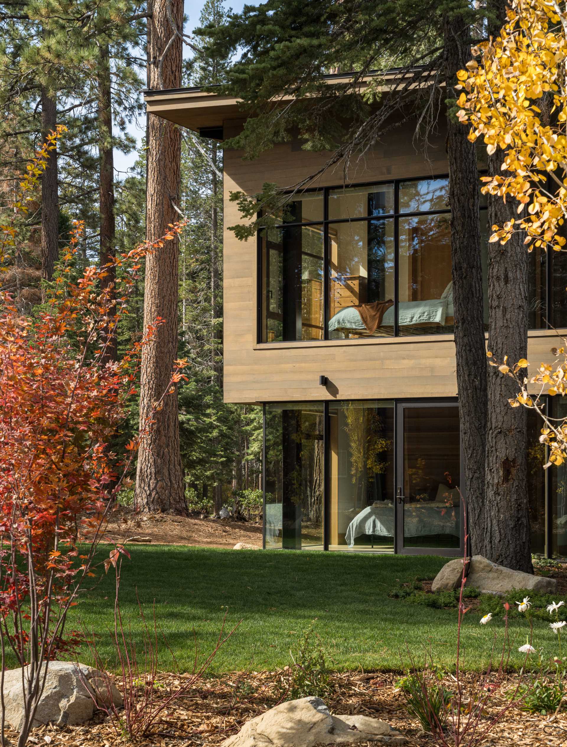 A modern home has an intentionally muted yet refined palette of natural materials including cedar, oak, fir, and steel, allowing the house to harmoniously blend with the surroundings.