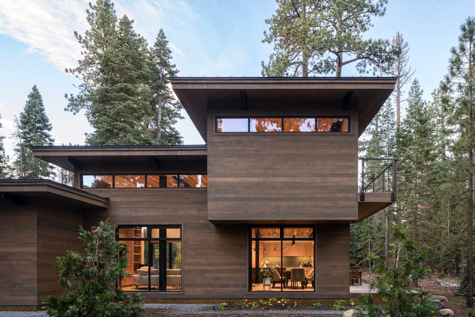 A modern home has an intentionally muted yet refined palette of natural materials including cedar, oak, fir, and steel, allowing the house to harmoniously blend with the surroundings.