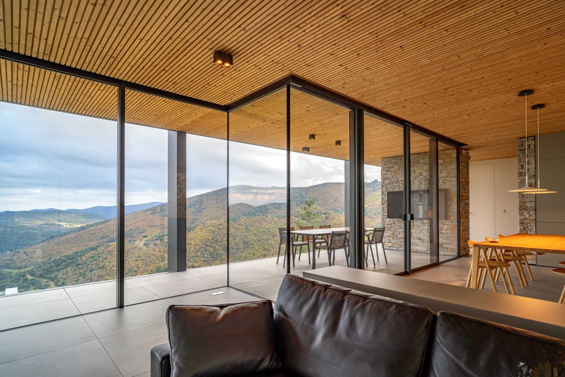 A modern home with an open plan interior and floor-to-ceiling windows.