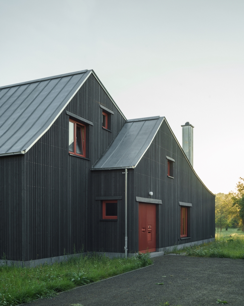 dark wooden facade by ko/ok architektur contrasts semi-detached gabled house in germany