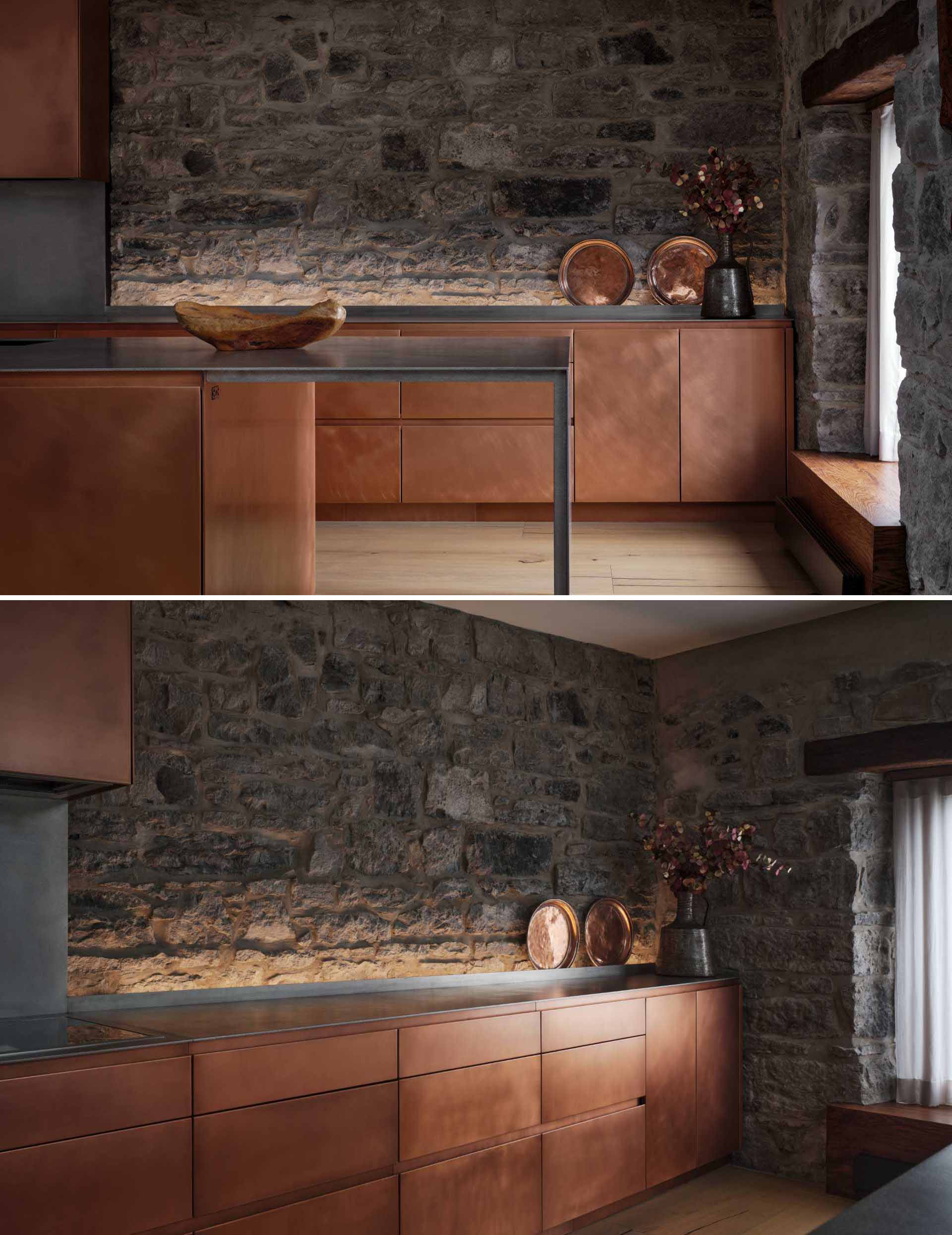 This modern kitchen in a renovated historic loft, features striking copper cabinetry and a stainless steel countertop.
