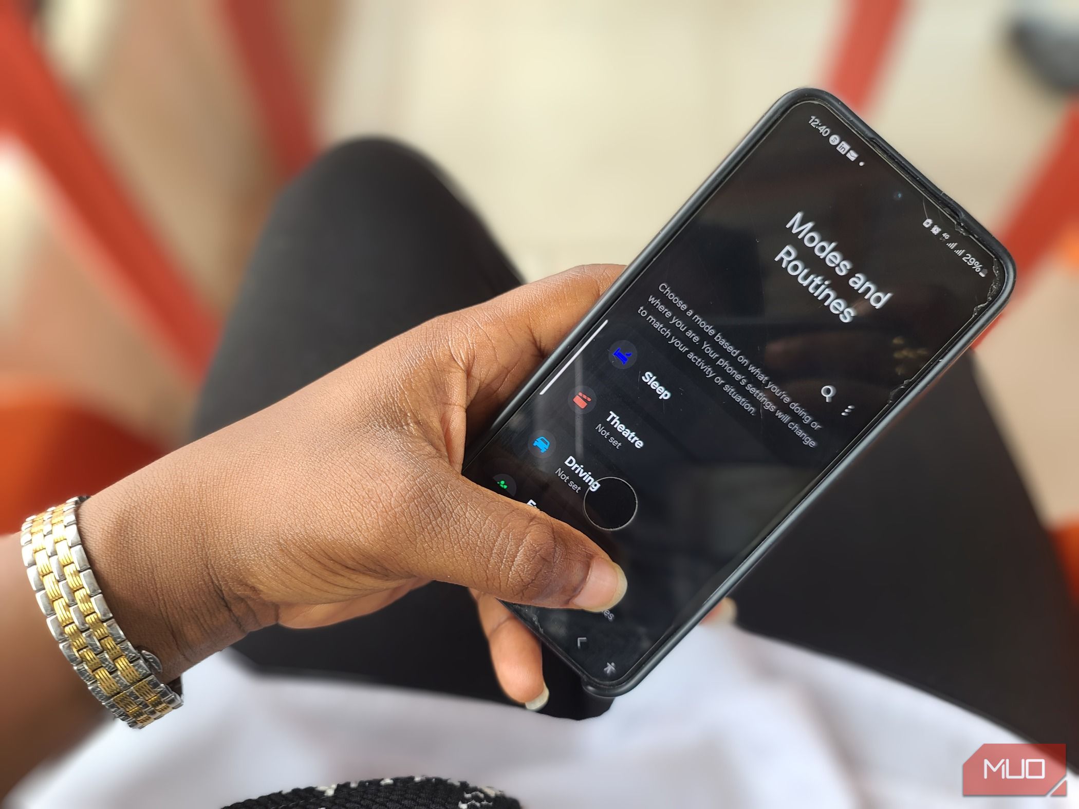 Hand holding a Samsung phone showing Mode and Routines