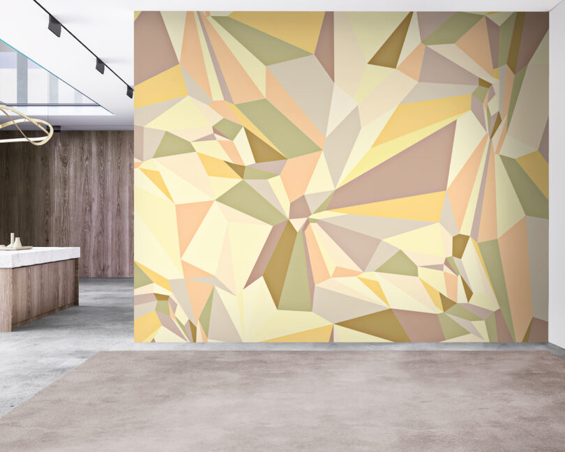 A modern interior with a geometric, multicolored accent wall in shades of yellow, beige, and brown, adjacent to a marble counter and wooden paneling