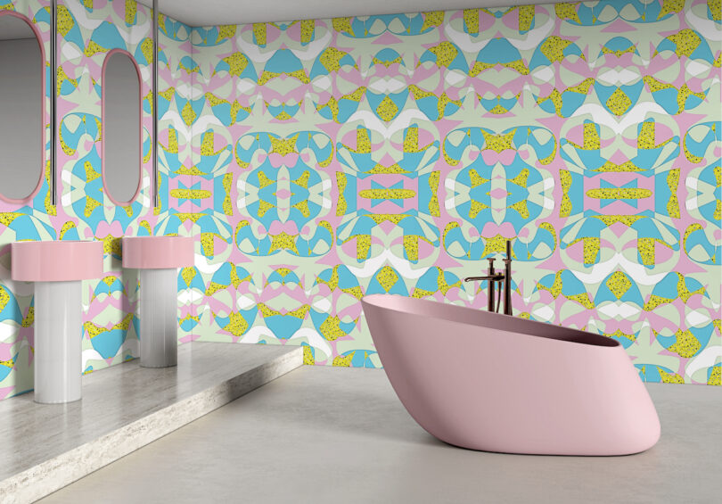 A modern bathroom with a pink bathtub and sinks, featuring walls covered in colorful, geometric retro wallpaper in pastel shades of pink, blue, yellow, and green
