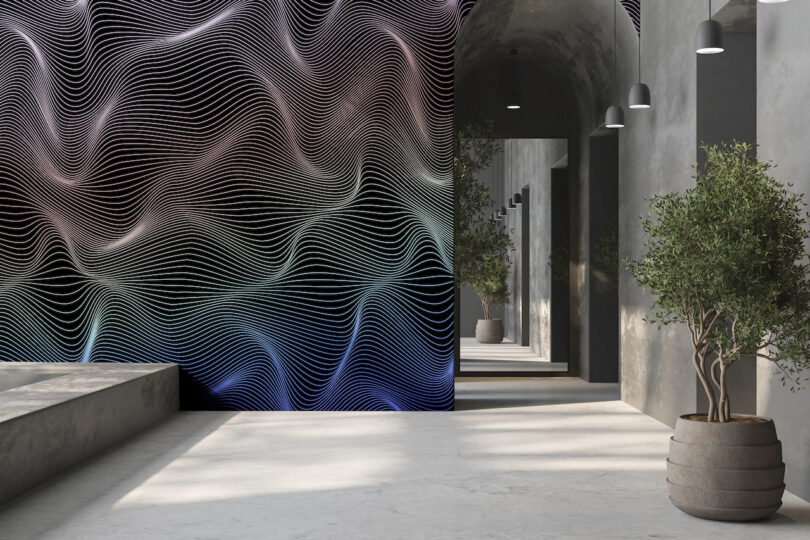 A modern hallway with concrete walls and floor, potted plants, and a large, colorful wavy line mural on one wall
