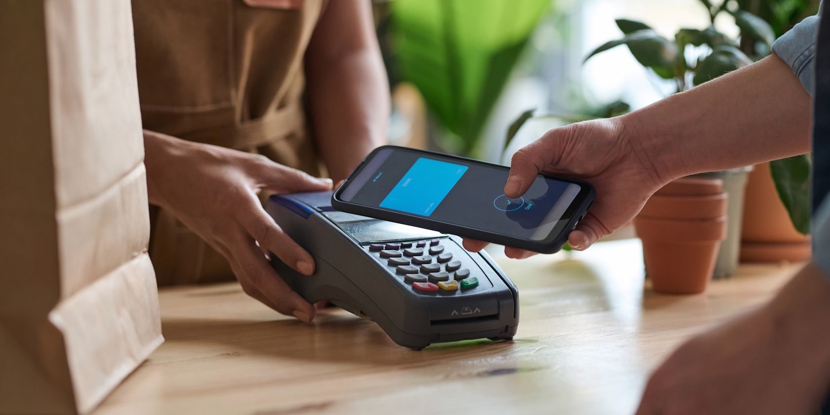A guy making an NFC payment using his smartphone at a grocery store