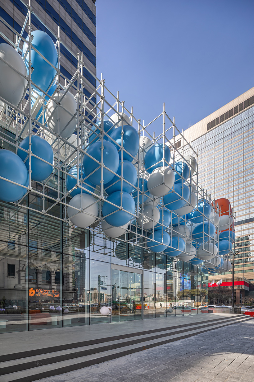 vibrant balloons nestle within metallic scaffolding atop seoul's playful urban hub by SSP