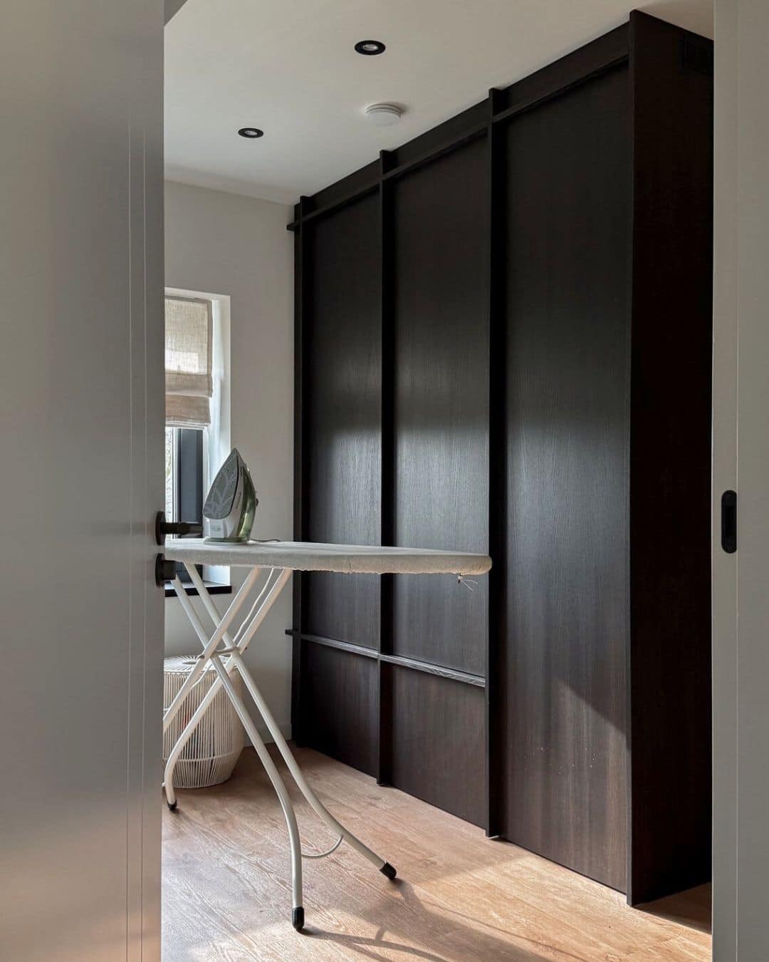 Peek-a-Boo Laundry: Hide Your Washer + Dryer in Plain Sight 16 Laundry room with a hidden washing machine in IKEA kitchen cabinet, in front of the built-in cabinets is an ironing board with iron on top