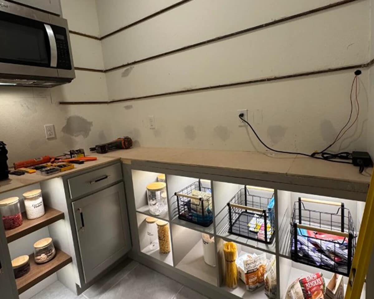 a kitchen pantry with shelves and a microwave