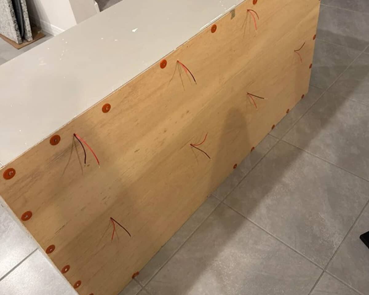 a wood board with red ties covering the back of the KALLAX shelving unit