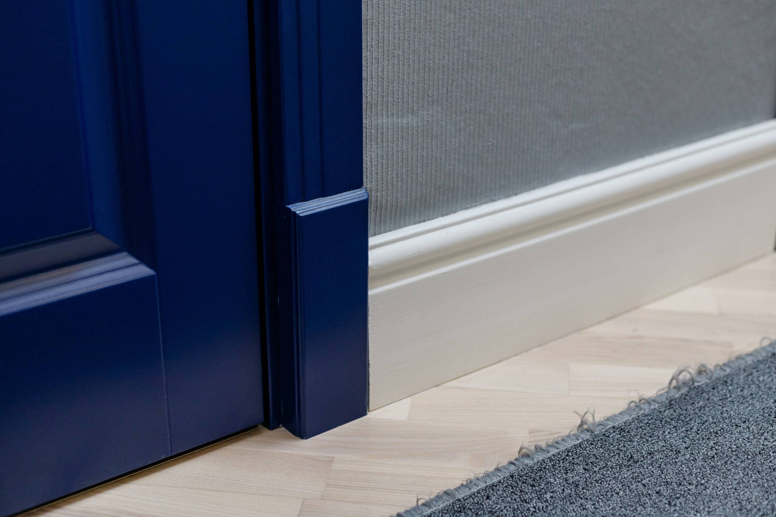 Blue wooden door and adjoining high classic floor plinth. Interior decor elements.