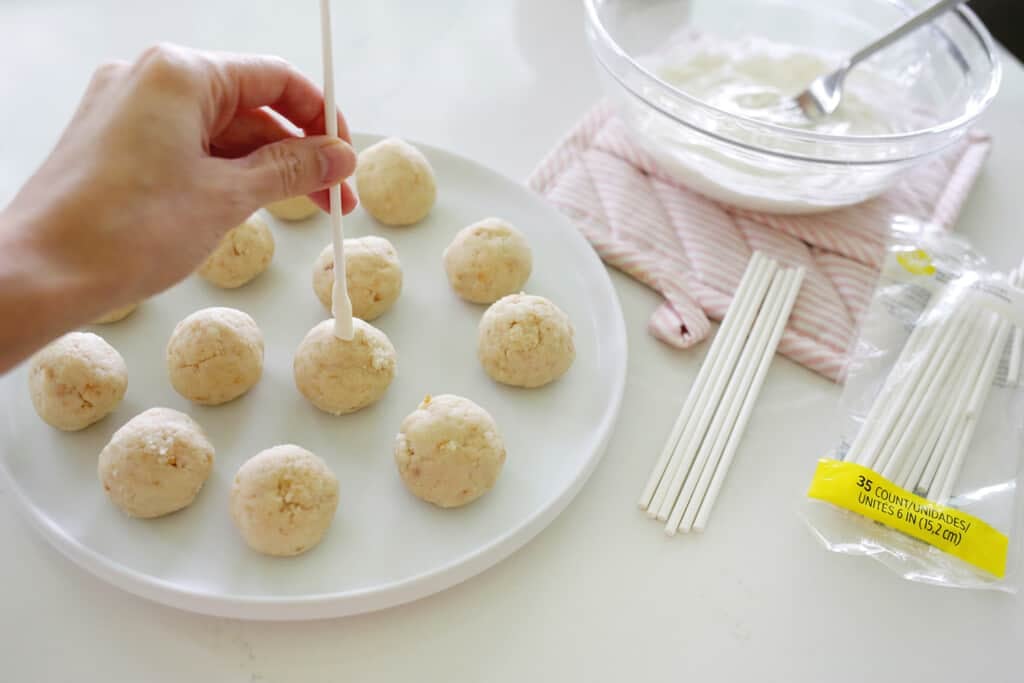 adding sticks to cake pops