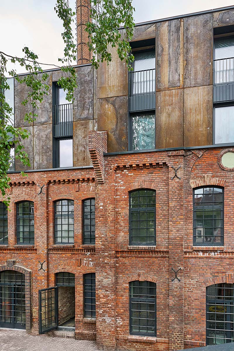 corten steel extends former laundry complex’s brick buildings in kassel