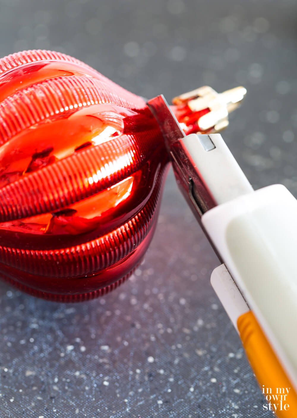 One way to cut a shatterproof Christmas ornament to make it into a lamp finial.