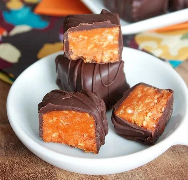 Chocolate-covered candy with a peanut butter filling on a plate.